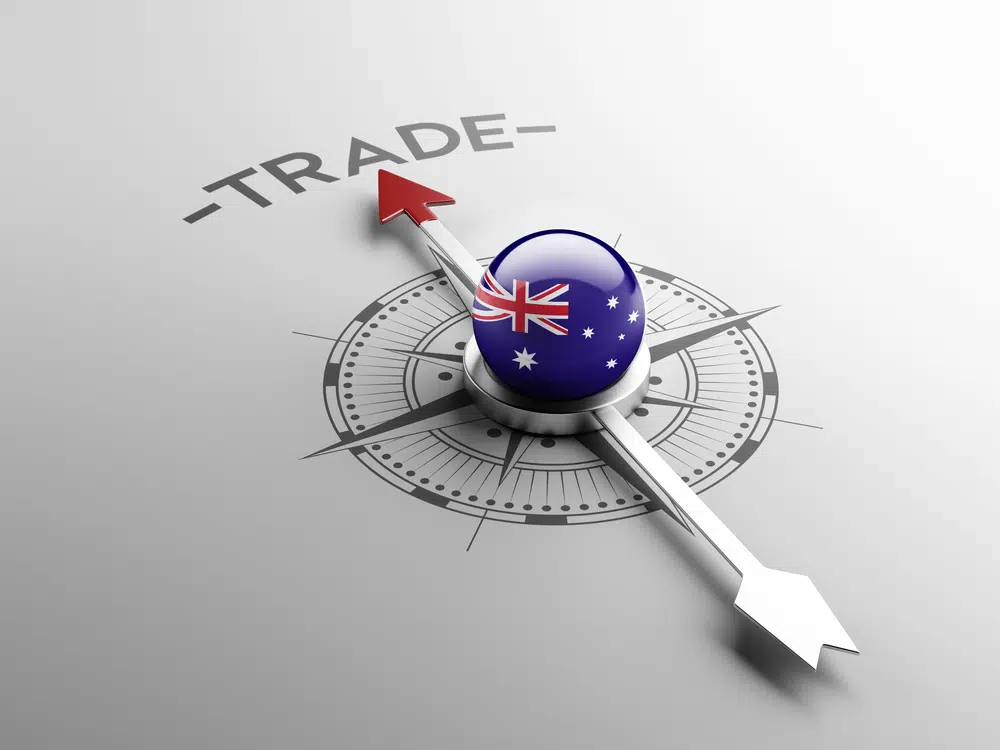 Image of a silver compass with an Australian flag in the centre, and the arrow pointing north toward the word ‘trade’ - symbolic of Australia focused on its new trade partnership with India